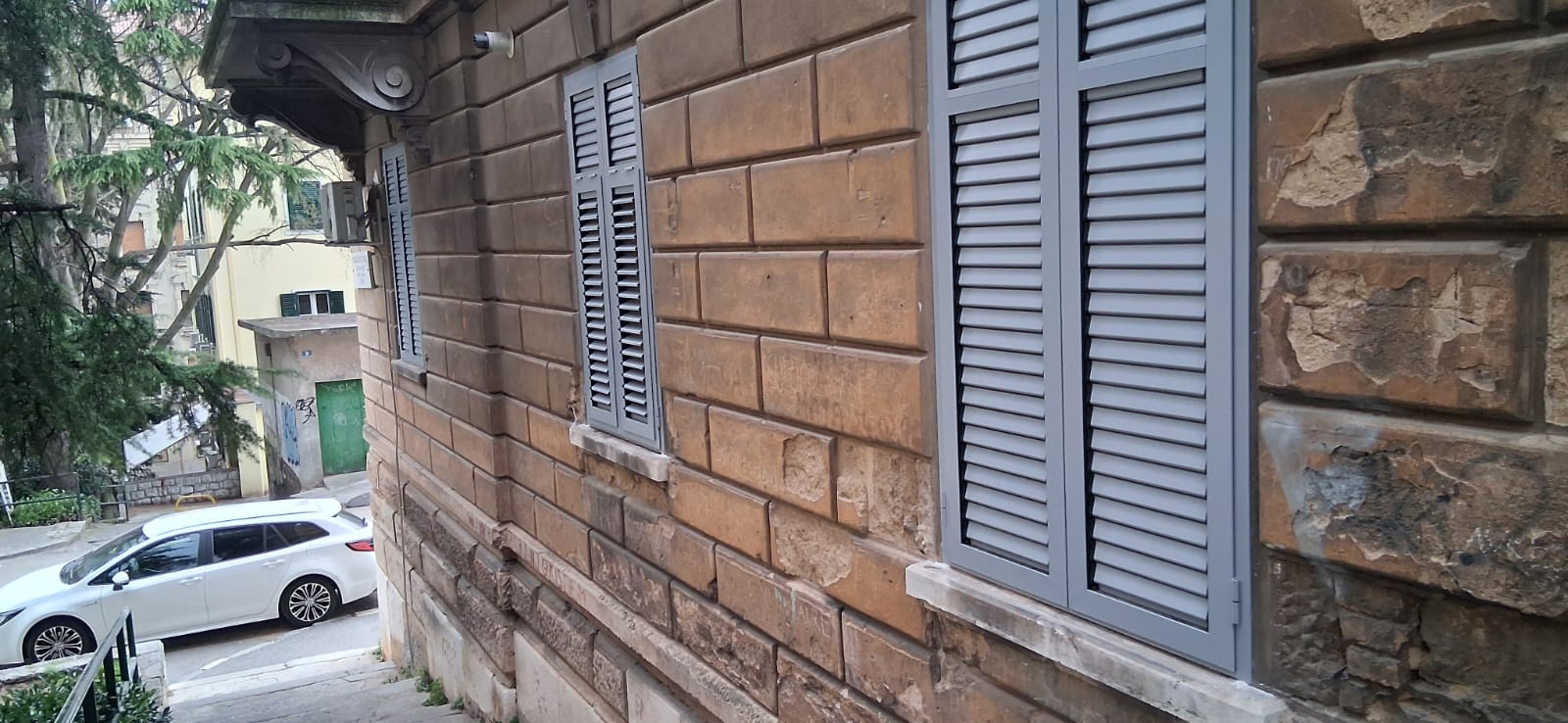 Plave aluminijske grilje na kamenoj fasadi, stara jezgra Rijeke